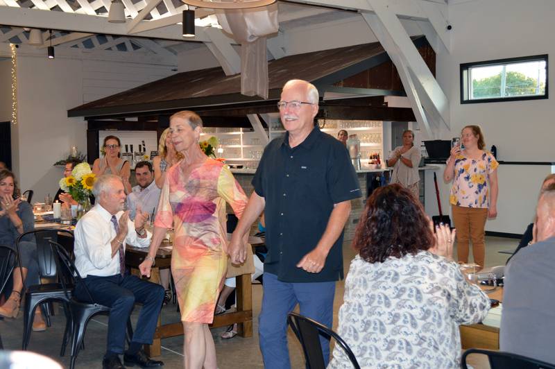 Oregon Area Chamber of Commerce 2023 Citizens of the Year James Brown, right, and Karen Virnoche walk hand-in-hand to accept their award during the Chamber's annual dinner at River's Edge Experience in Oregon on Thursday, Aug. 17, 2023.