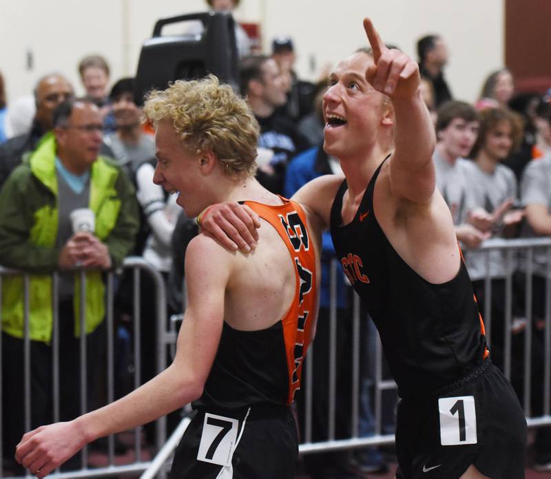 Micah Wilson, right, and Jed Wilson of St. Charles East celebrate their repective first and second place finishes in the 3,200-meter run during the DuKane boys indoor track meet at Batavia High School Saturday.