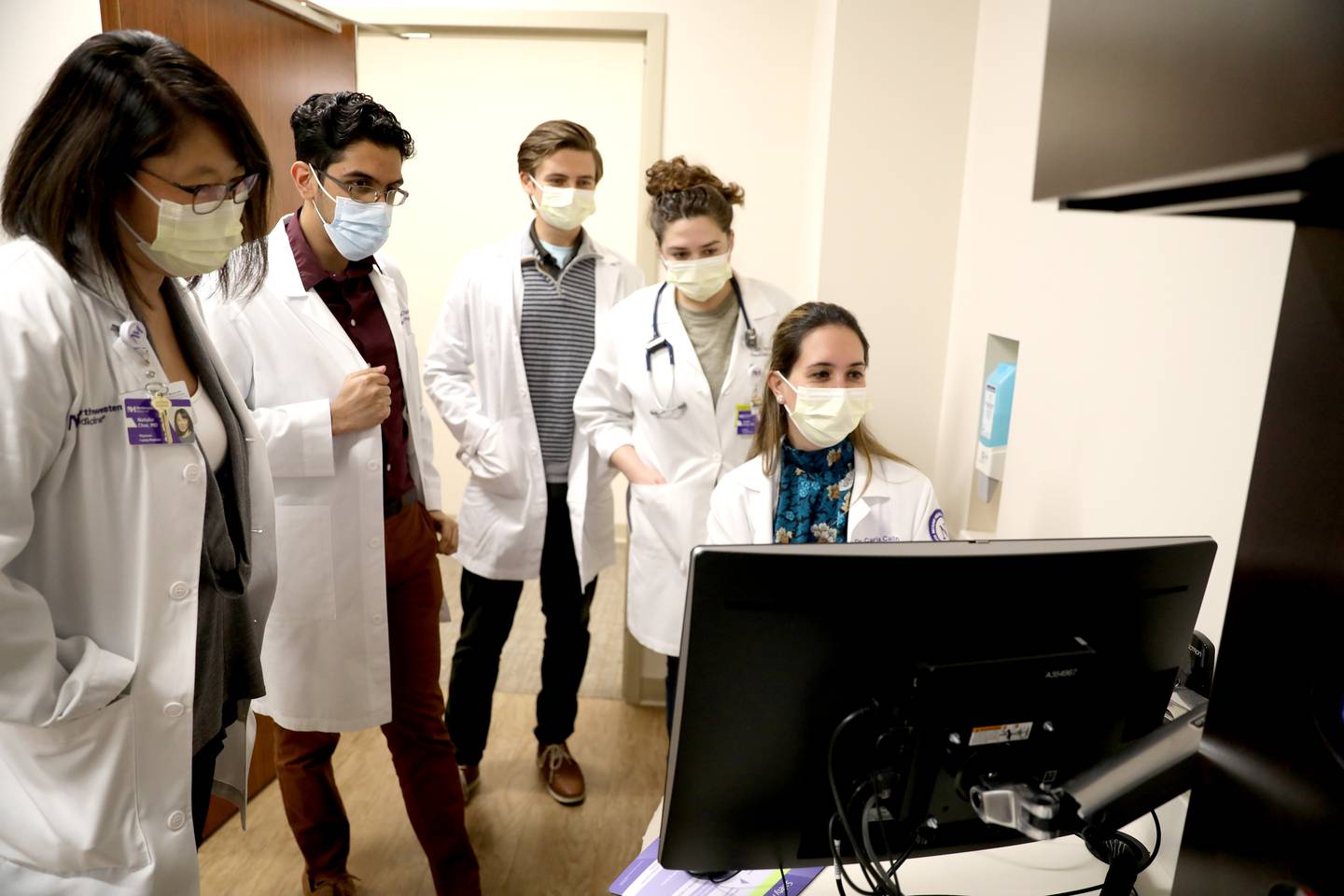 Carla Cavallin (seated), who is in her second year in the Northwestern Medicine Delnor Hospital residency program, works in a patient room of the program’s clinic with (from left) Residency Program Director Natalie Choi, residents Ameel Chaudhary, Trevor Gohl and Ischel Kelso on Thursday, Dec. 15, 2022 in Geneva.