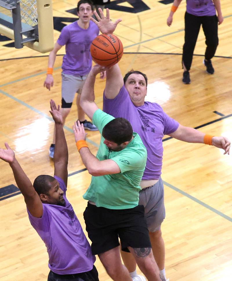Sycamore School Staff team member Nate Wright blocks the shot of Fire/Police team member Grayson Zepeda Thursday, Dec. 19, 2024, during the Heroes on Hardwood basketball game at Sycamore High School. The basketball game, which is a fundraiser for the Spartan Food Pantry, pits a team of Sycamore first responders against a squad of Sycamore School District 427 staff.