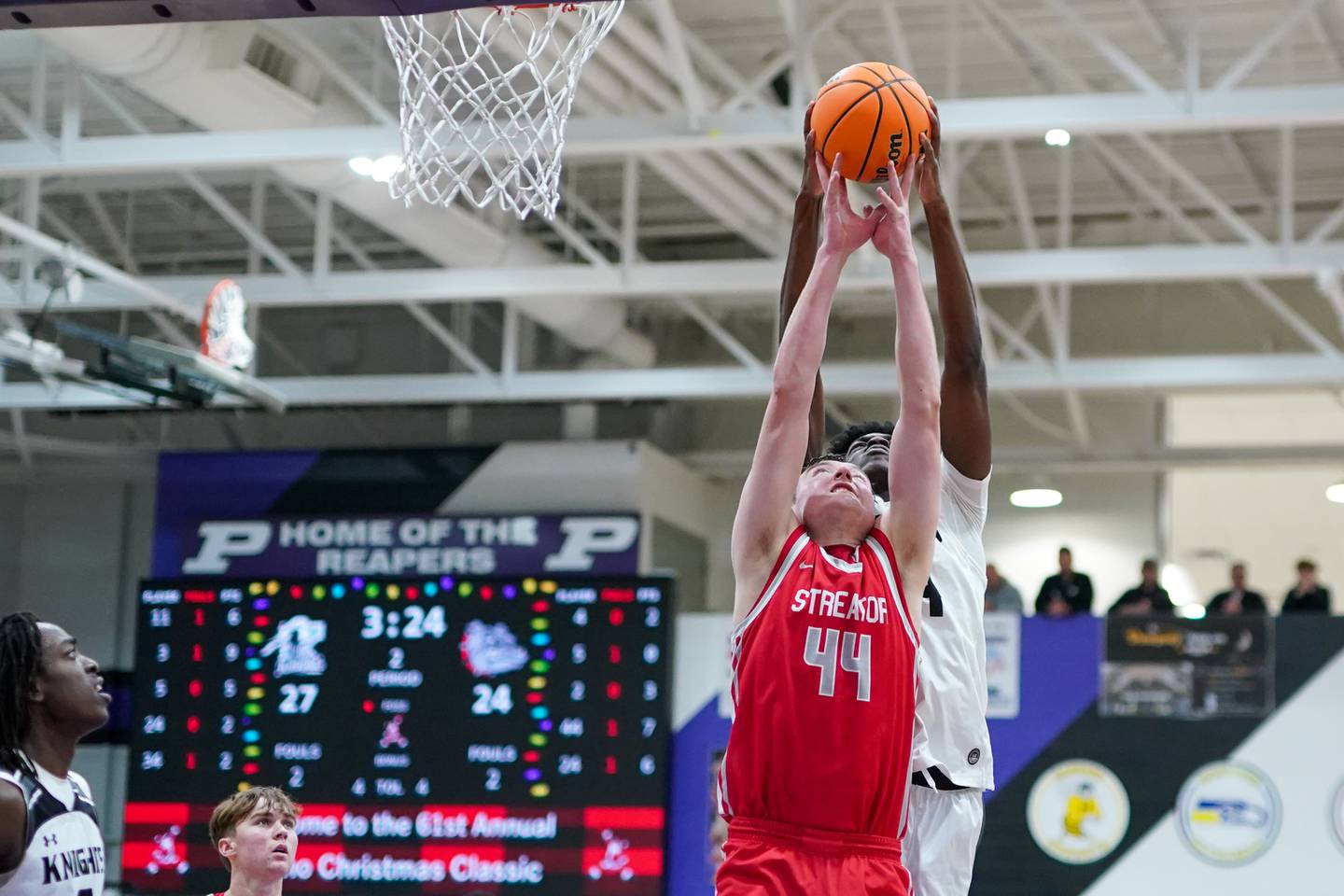Kaneland’s Jeffrey Hassan (34) rebound the ball over Streator's Nolan Lukach (44) during a semi-final basketball game in the 61st annual Plano Christmas Classic at Plano High School on Friday, December 27, 2024.