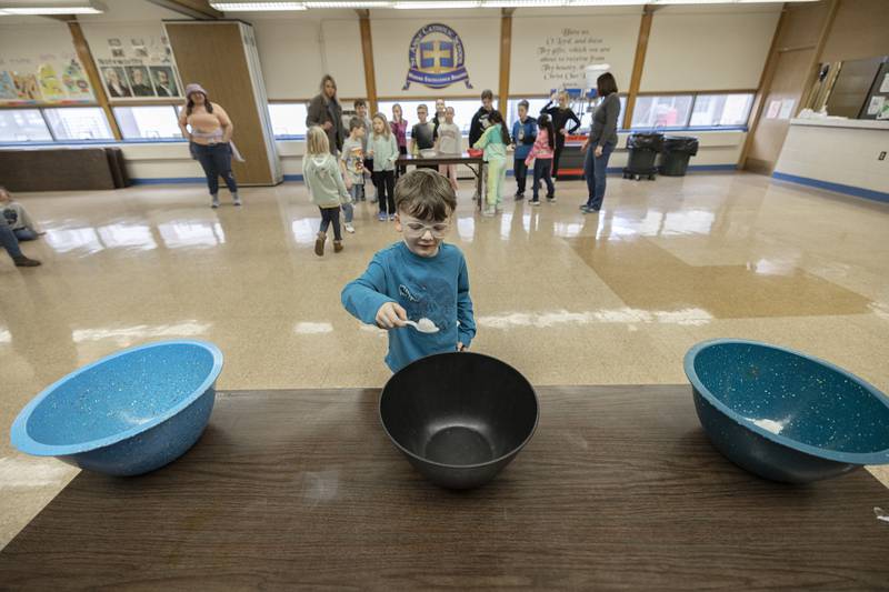 Henry Sehr, kindergartener at St. Anne’s school, drops a cotton ball into a bowl Tuesday, Jan. 30, 2024. St. Anne’s spent a few hours of fun for the day in celebration of Catholic Schools Week.