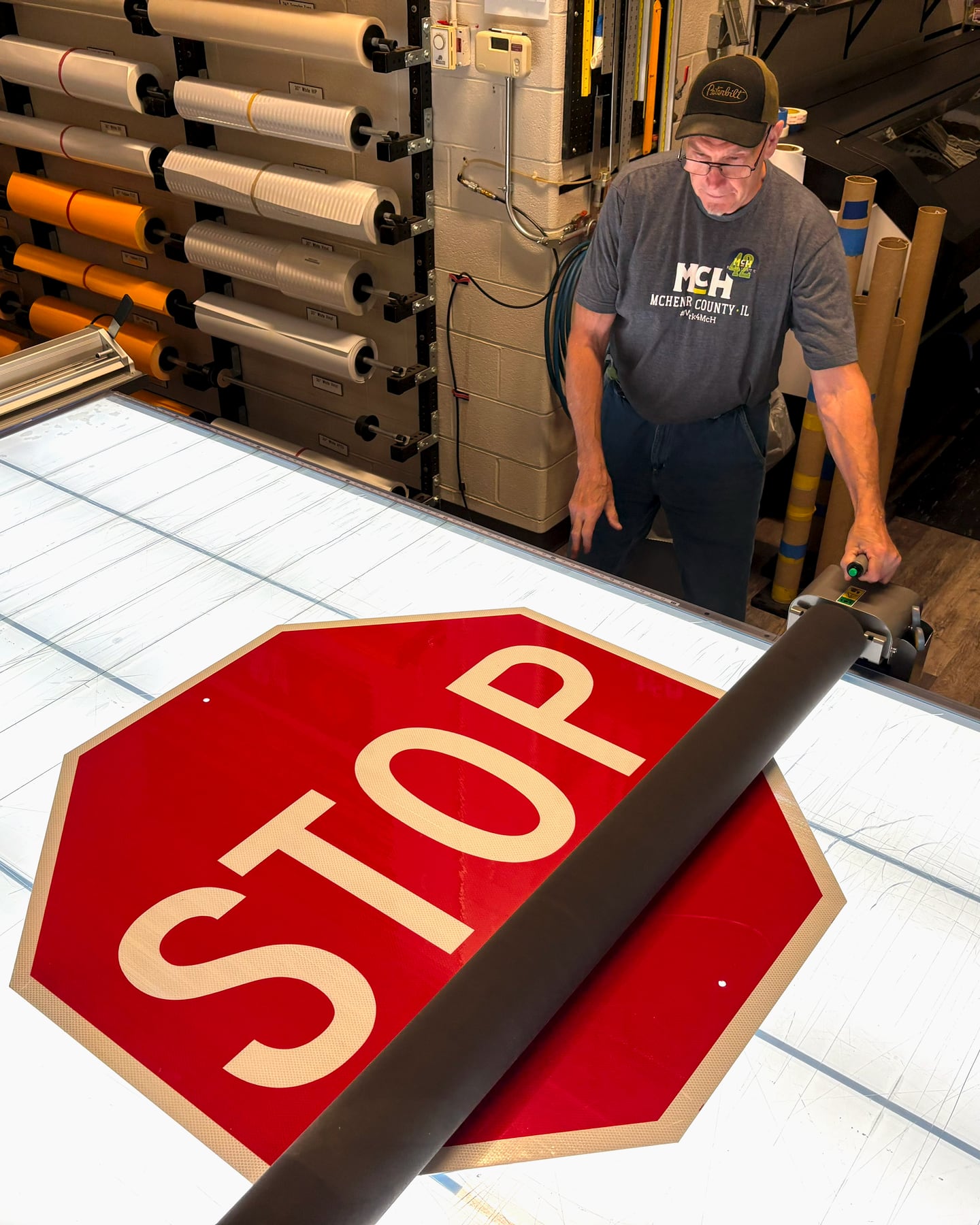 McHenry County sign shop supervisor Andrew Rose works on a stop sign in June 2025.