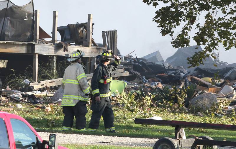Firefighters overlook the smoldering rubble of a house Tuesday, Oct. 17, 2023, after an explosion at the residence on Goble Road in Earlville. Several fire departments responded to the incident at the single-family home that left one person hospitalized.