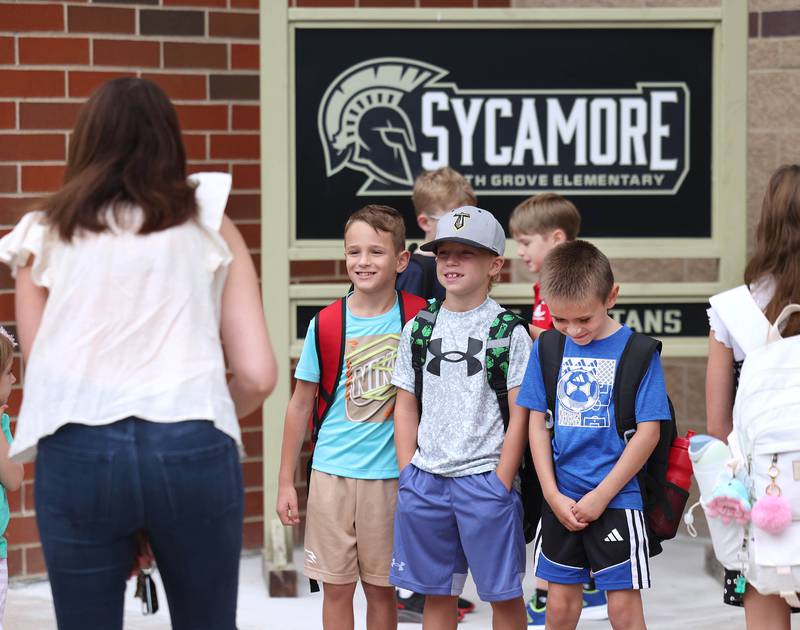 A group of students line up for a photo in front of the Spartan sign Thursday, Aug. 21, 2025, as they arrive for the first day of school at North Grove Elementary School in Sycamore.