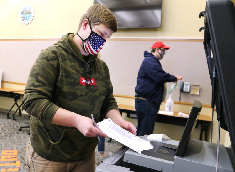 Shawn McCarty, of Sycamore, inserts his ballot into the collection machine after voting Friday during early voting at the polling place located inside the DeKalb County Legislative Center.