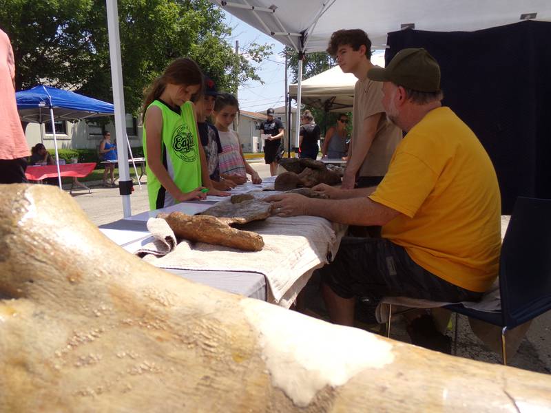 (Front to back) Shane, Colter and Selby O'Brien talk to T-Rexplorers about dinosaur bones Saturday, June 3, 2023, at the Summer Reading Kick-Off Party at Reddick Library in Ottawa. T-Rexplorers demonstrated authentic dinosaur bones and educated families about dinosaurs.