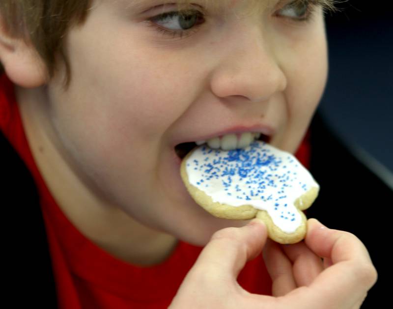 Asher Markowitz, 11, of Fox River Grove enjoys a cookie during a Chanukah party at The McHenry County Jewish Congregation Sunday.