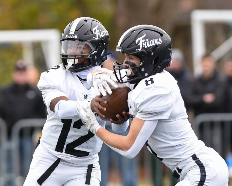 Fenwick's Jamen Williams (12) hands the ball to teammate Jake Thies (8) during the game on Saturday Nov. 22, 2025, while taking on Nazareth Academy on Saturday Nov. 22, 2025, held at Nazareth Academy High School in La Grange Park.