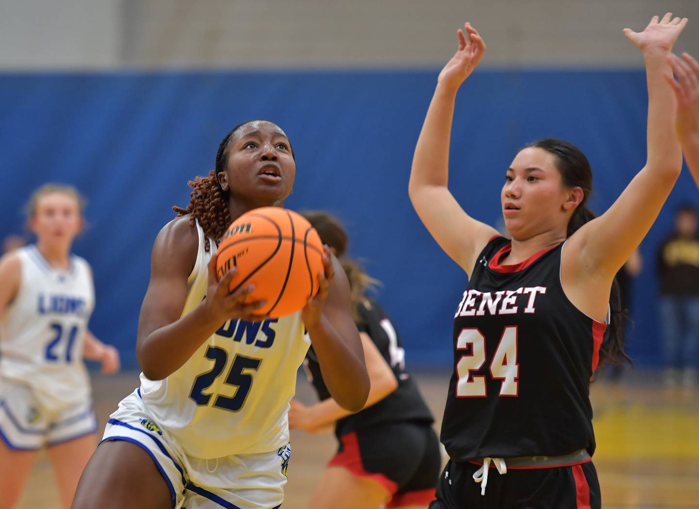 Lyons Township's Nora Ezike (25) goes to the basket as Benet's Emma Briggs (24) defends during a game on November 19, 2024 at Lyons Township High School in LaGrange.