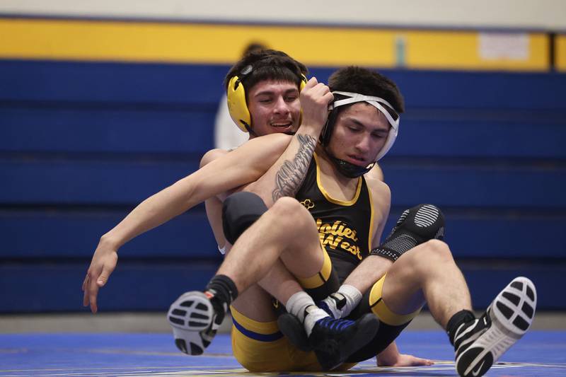 Joliet Central’s Aleck Allende works behind Joliet West’s Joseph Pedrosa in the 120-pound weight match at Joliet Central on Friday, Jan 31, 2025.