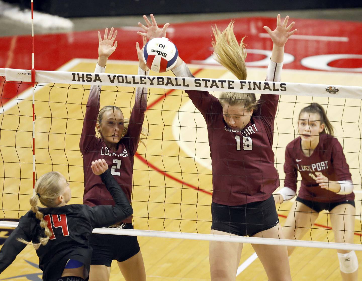 Lockport's Emily McGraw (2) and Jenna Kolosta (18) try to stop a shot by Huntley's Julia Lesniak (14) during the IHSA Class 4A girls volleyball third place match Saturday, Nov. 16, 2024 at CEFCU Arena in Normal.