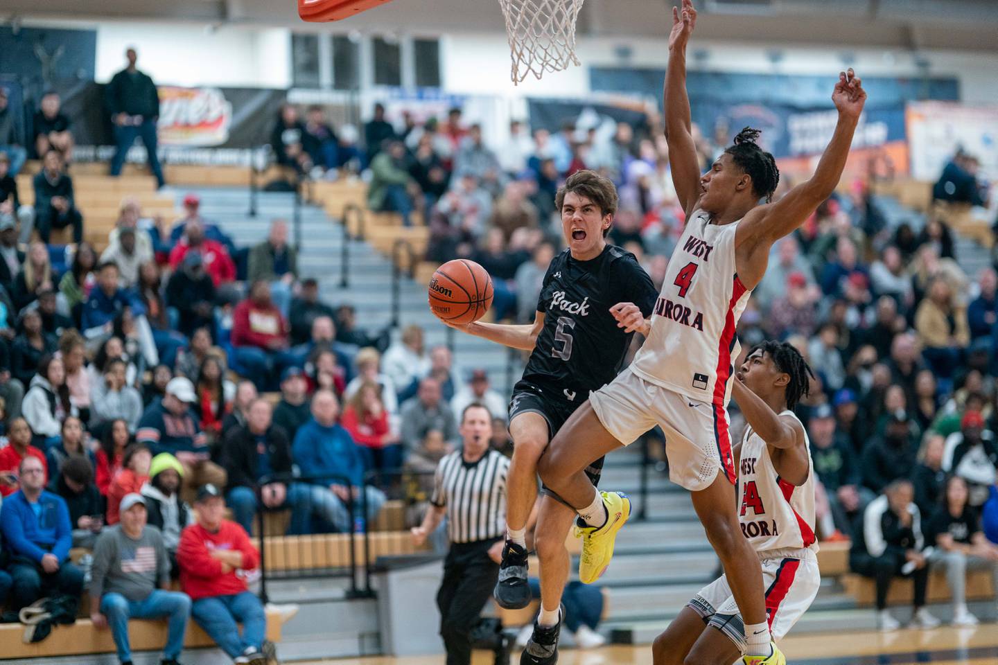 Oswego East's Mason Blanco (5) drives to the basket against West Aurora's Joshua Pickett (4) during the hoops for healing basketball tournament at Oswego High School on Friday, Nov 25, 2022.