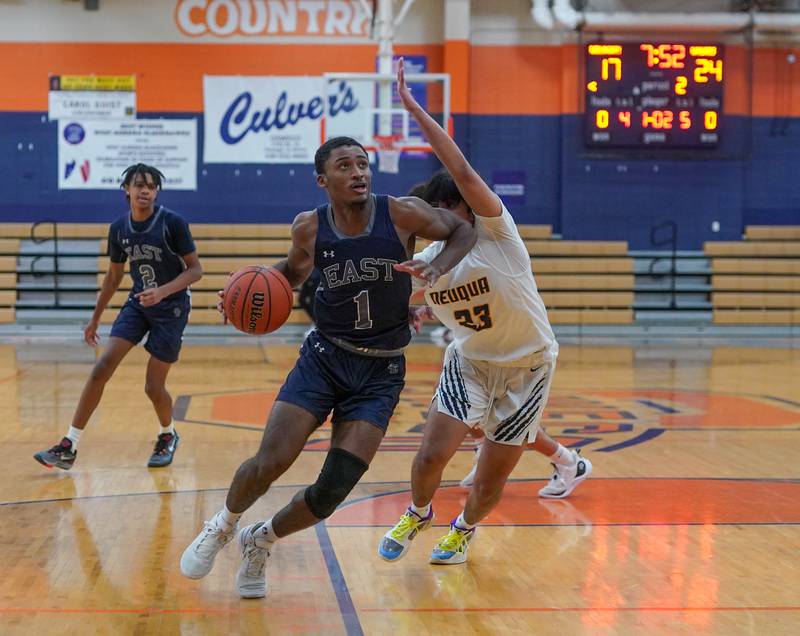 Oswego East's Andrew Wiggins (1) drives to the basket against Neuqua Valley's James Coviello (23) during a hoops for healing basketball tournament game at Oswego High School on Friday, Nov 24, 2023.