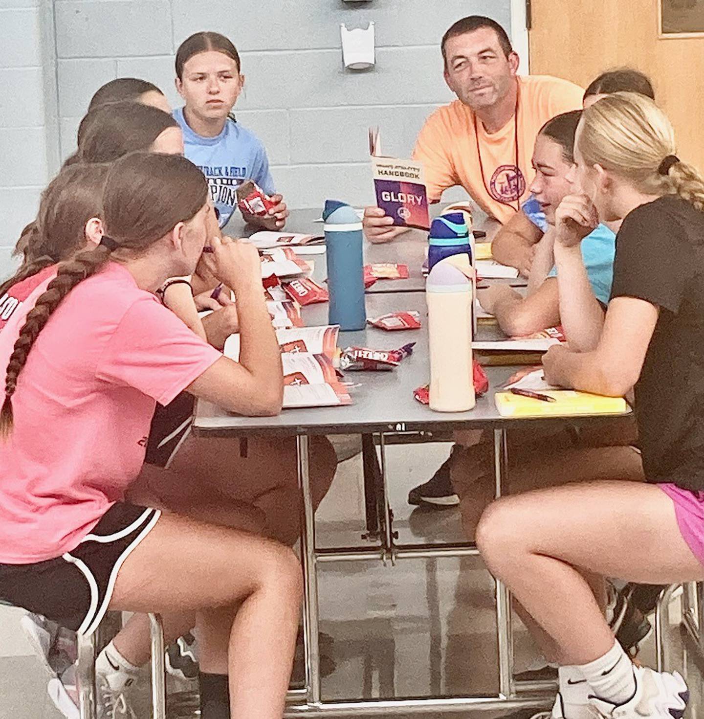Huddle leaders Emily Wright (left) and coach Brent Jamison lead the devotional Huddles during the Bureau Valley High School Fellowship of Christian Athletes Basketball Camp Tuesday morning.