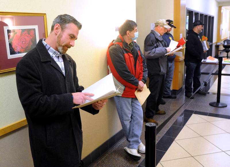 McHenry County sheriff candidate Robb Tadelman, right, looks over his forms the morning of Monday, March, 7, 2022, at the McHenry County Clerk's Office in Woodstock. Monday was the first day for candidates to file ahead of the June primaries. This election season includes all McHenry County Board seats, the clerk, sheriff and regional superintendent of education. The candidates were trying to get the first slot on the ballot by filling at 8 a.m. When more than one candidate applies at a time, a lottery is held.