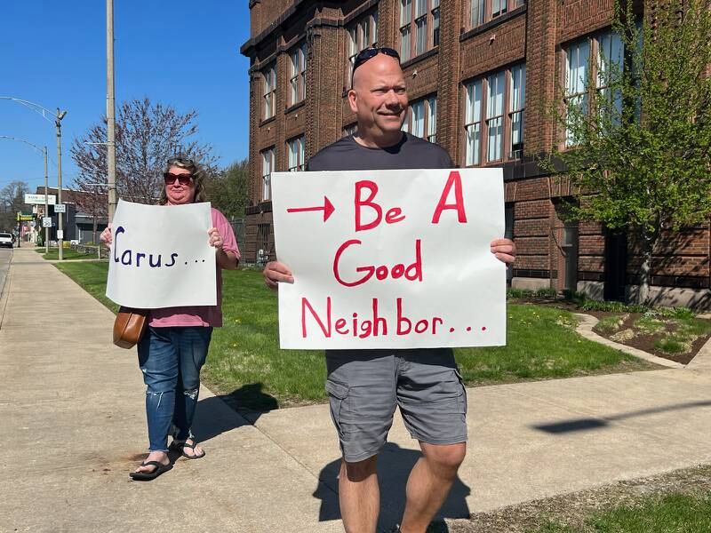 La Salle Mayor Jeff Grove (front) and resident Lisa Dyas march in front of the Carus LLC offices in Peru on Wednesday, April 12, 2023, asking for more dialog with the company after a Jan. 11 fire at the company's La Salle plant.
