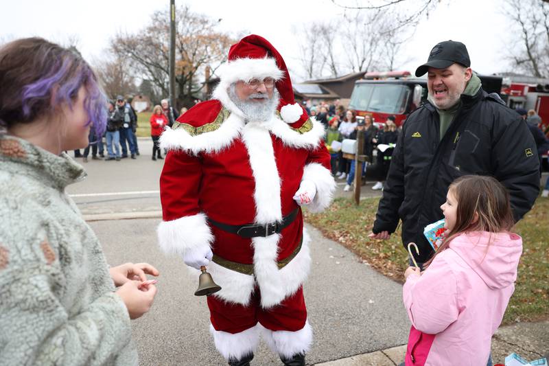 Santa talks to the Jenicek family as volunteers from Lockport Love deliver gifts to the family on Saturday, Dec. 10, 2022, in Lockport.