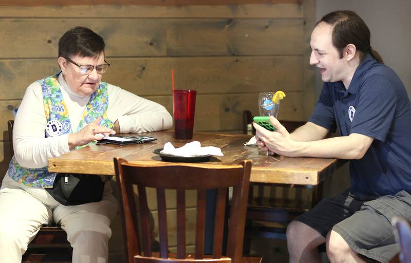 Shell DeYoung Dunn, candidate for County Board District 11, and her son Nik Stromberg, from Somonauk, try to find election numbers on their phones Tuesday, June 28, 2022, during a Democrat candidate watch party at Fatty's Pub and Grille in DeKalb.