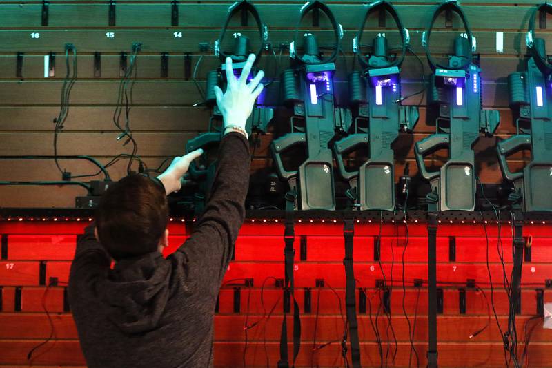 Associate Andrew Gordon sets out laser tag guns on the counter for customers at Twisted Limits Laser Tag on Tuesday, Dec. 14, 2021, in McHenry.  The business opened last December.