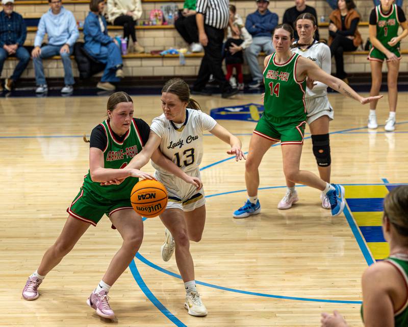 Alexus Hines (4) of LaSalle-Peru dribbles ball near top of key whilst Emily Adair (13) of Marquette reaches across body in attempt to steal ball on Saturday, January 3, 2026 at Marquette Academy in Ottawa.
