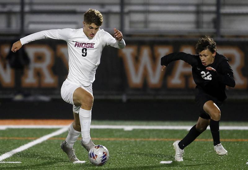 Prairie Ridge's Henry Knoll pushes the. Ball up the field as he is defended by McHenry's Evan Camargo during a Fox Valley Conference soccer match on Tuesday, Oct. 15, 2024, at McCraken Field in McHenry.