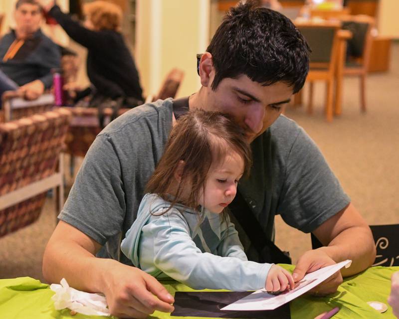 Francisco Castillo and his daughter Isla Castillo, 1 ½ year old, make a pinhole solar eclipse viewer at the Wheaton library before the start of the solar eclipse on Monday April 8, 2024.