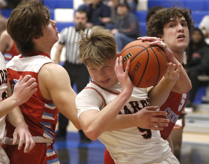 DeKalb's Tyler Vilet grabs a rebound between Marian Central's Jackson Jakubowicz and Sean Truckenbrod during a Central High School’s Dr. Martin Luther King, Jr., Boys Basketball Tournament game Friday, Jan. 13, 2023, at Central High School in Burlington.