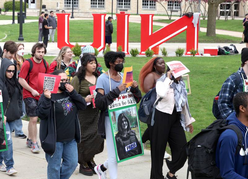 A group of about twenty demonstrators chant slogans as they march past the NIU sculpture at Northern Illinois University in DeKalb Monday, April 29, 2024, to protest the Israel-Hamas War.