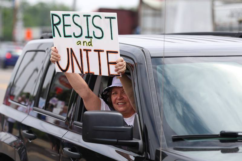 A person holds a sign out there window as the drive down West Jefferson Street at the Larkin Avenue intersection during the No Kings Day protest on Saturday, June 14, 2025 in Joliet.