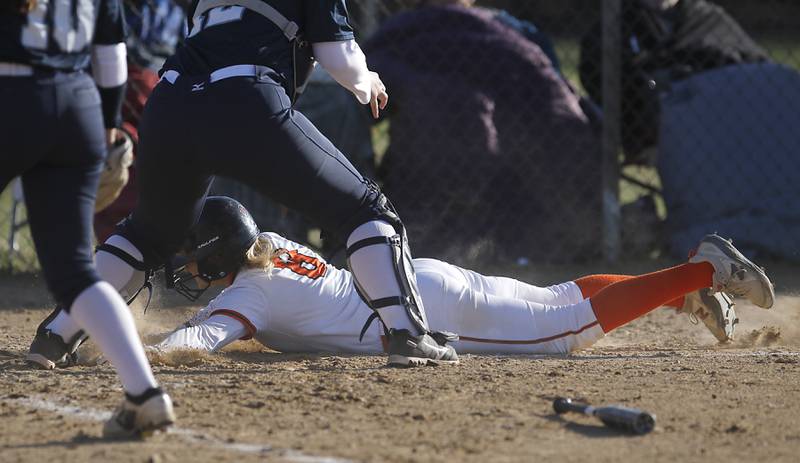 Crystal Lake Central’s Giada Motto dives into home to score a run during a Fox Valley Conference softball game against Cary-Grove Thursday, April 6, 2023, at Crystal Lake Central High School.