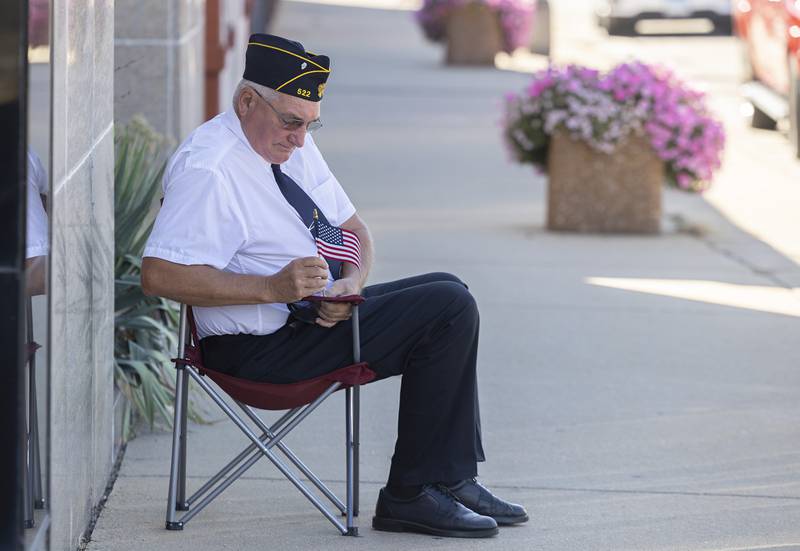 Navy veteran Jeff Dever of Prophetstown places a flag on his chair Thursday, August 31, 2023 as he wait for the arrival of the Vietnam Traveling Memorial Wall to arrive in Rock Falls.