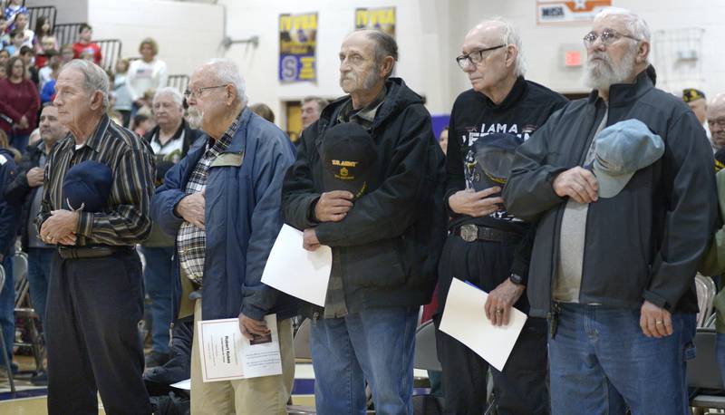 Local Veterans place their hats over their hearts during the Pledge of Allegiance at a Veterans Recognition Ceremony Tuesday at Serena High School.