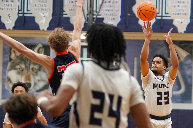 Oswego East's Torrin Ross (23) shoots a three pointer against Oswego during a basketball game at Oswego East High School on Saturday, January 14, 2017.