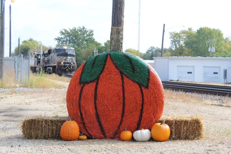 It's the Great Hay Pumpkin, Charlie Brown: Lightning Detail, a downtown car detailing business, made a pumpkin out of its bale, greeting trains along the BNSF Northern Transcon into town. The bale was part of the 2025 Hay Bale Trail in Rochelle throughout October.