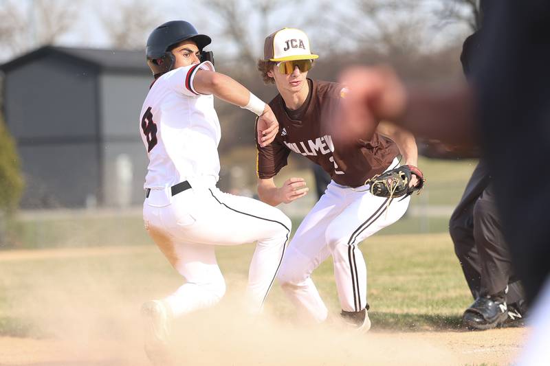 Lincoln-Way Central’s Dev Sharma and Joliet Catholic’s Johnny Curbis look for the passed ball at third base on Wednesday, March 25, 2026 in New Lenox.
