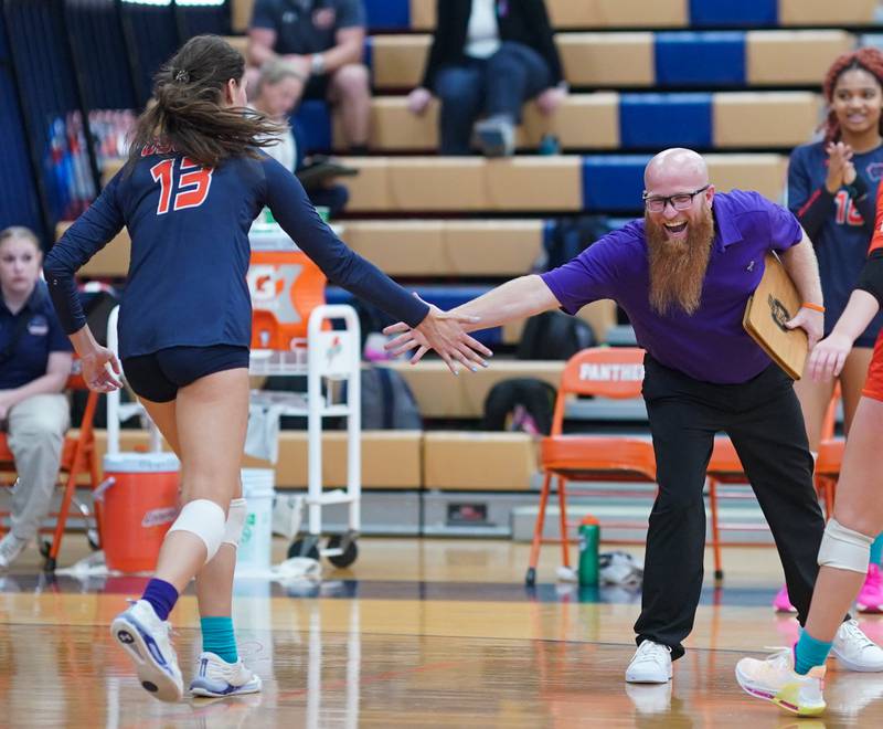 Oswego’s head coach Gary Mosley congratulates Oswego’s Sidney Hamaker (13) after scoring a point against Yorkville during a volleyball match at Oswego High School on Thursday, Sept. 14, 2023.