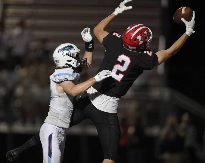 Maine South’s Ryan Pothast catches a touchdown pass against Prospect’s Charlie Knee in a Thursday night football game in Park Ridge on September 15, 2022.