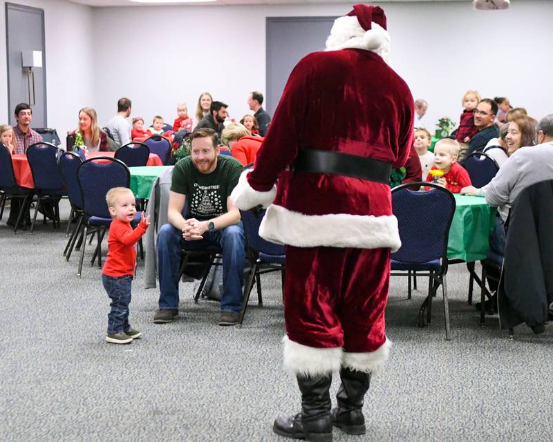 Charlie Hooker, 1, of Plainfield waves hello to Santa and Santa greats everyone on Sunday Dec. 15, 2024, during the breakfast with Santa event held at the La Grange Park District Recreation Center.