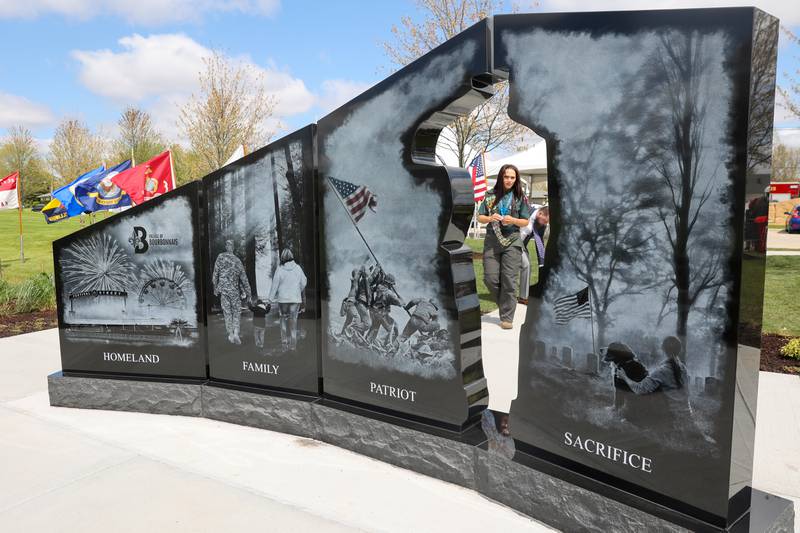 Alexis McCullough, 17, of Bourbonnais, is seen through the cutout in the new Gold Star Families Memorial Monument, which she successfully completed for her Eagle Scout project, following the dedication ceremony at Marcotte Park in Bourbonnais on Saturday, April 26, 2025.
The photo engraved above the word 'Family' on the monument shows McCullough walking hand-in-hand with her father, Col. Mark McCullough, who died in October 2019 while serving in the Army, and her mother, Cassandra.