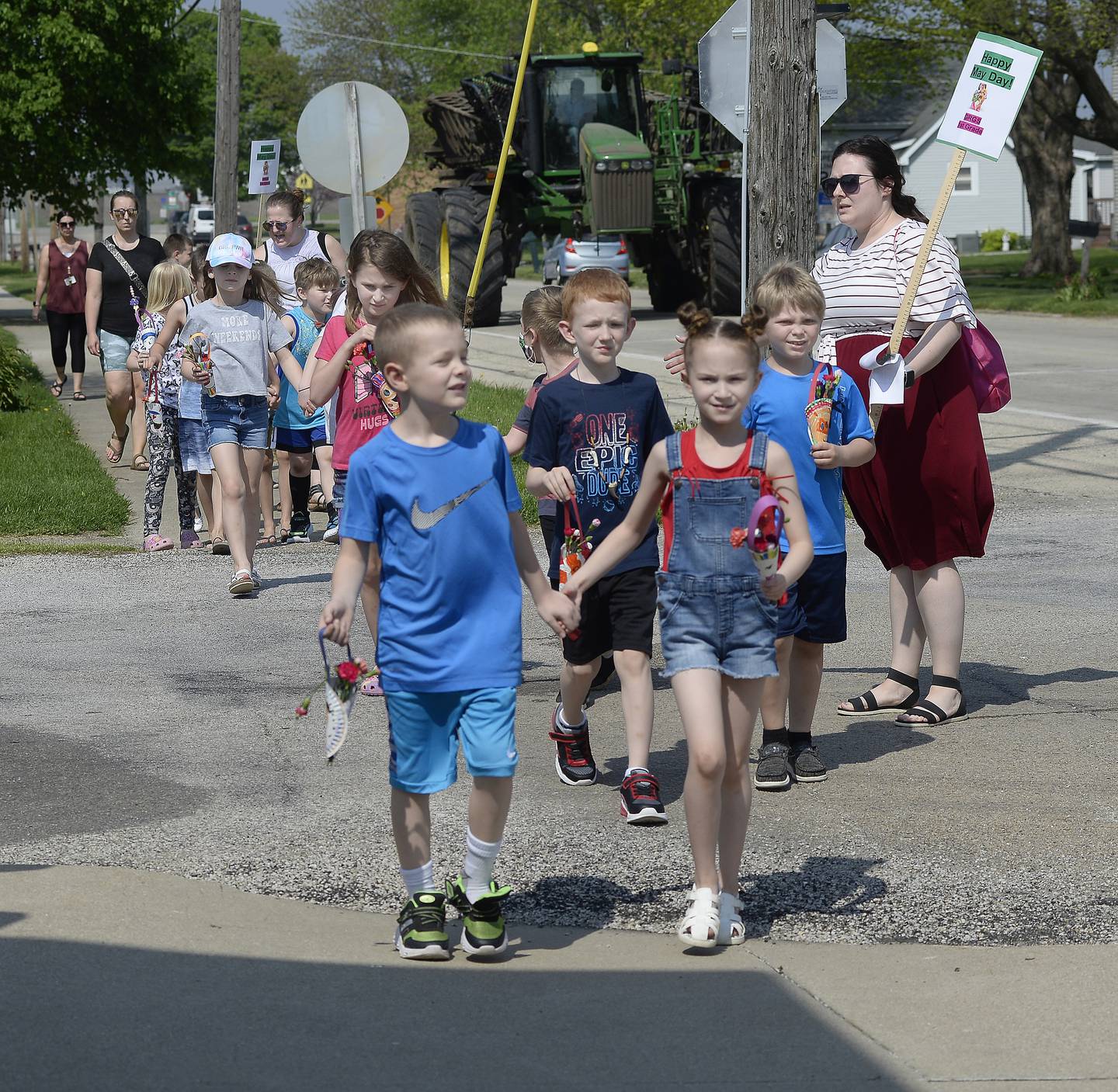 After leaving Grand Ridge Grade School, kindergarten through second grade students walk through the village Thursday, May 12, 2022, delivering May baskets to residents.