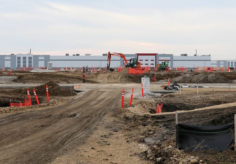 Grading and preparations for building construction are underway Tuesday, Dec. 14, 2021, on the plot of land at the corner of East Gurler Road and Crego Road in the ChicagoWest Business Center in DeKalb. Amazon recently paid $6.3M for the 59 acre parcel. The building in the background is the Ferrara Candy Company.