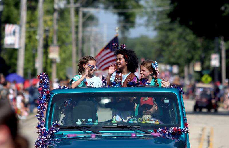 Kids from Troop 779 wave from atop a Jeep during the Huntley Independence Day Parade along Main Street in Huntley on Friday, July 4, 2025.