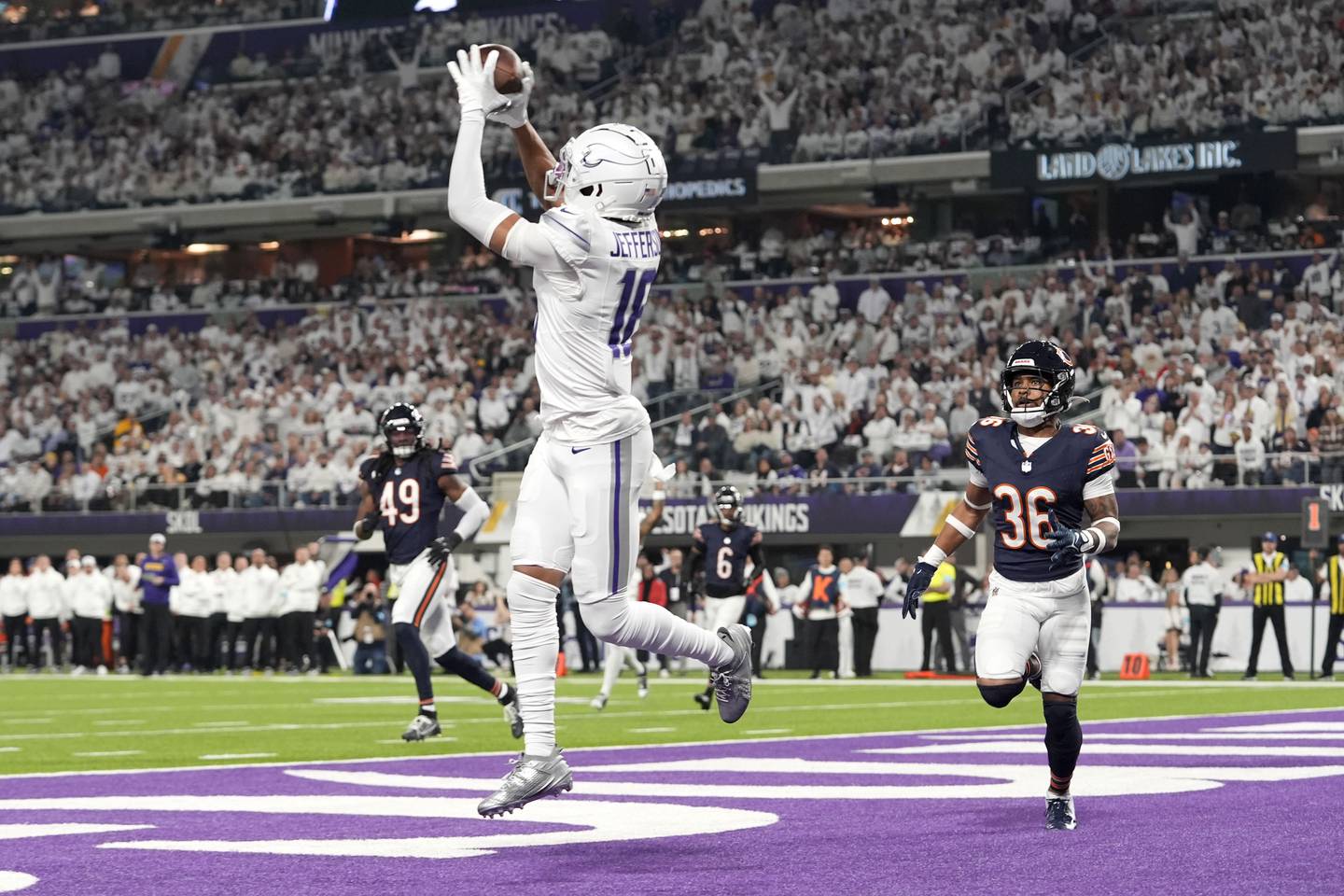 Minnesota Vikings wide receiver Justin Jefferson (18) catches a 7-yard touchdown pass in front of Chicago Bears safety Jonathan Owens (36) during the first half of an NFL football game, Monday, Dec. 16, 2024, in Minneapolis. (AP Photo/Abbie Parr)