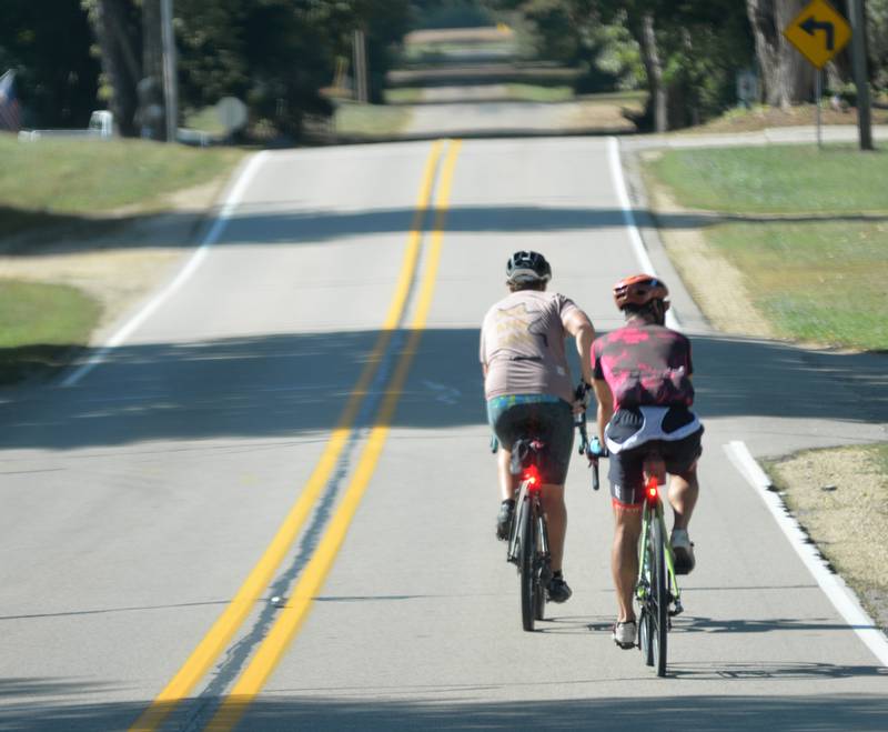 Two bicyclists ride into Grand Detour on Ridge Road during the 10th annual TOSOC (Tour of Scenic Ogle County) on Saturday, Sept. 27, 2025.