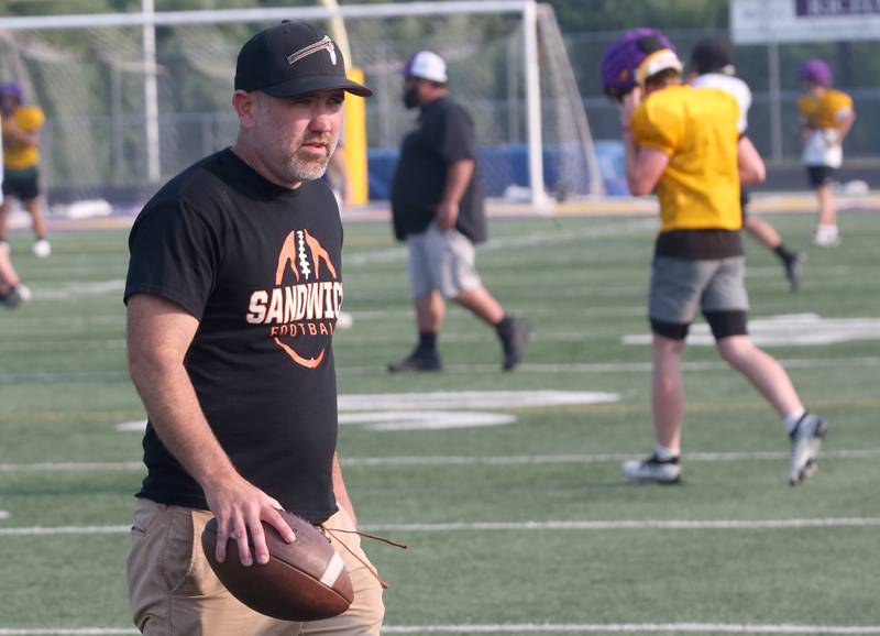 Sandwich football head coach Jason Van Pelt carries a football to the sidelines during a joint practice on Thursday, July 31, 2025 at Mendota High School.