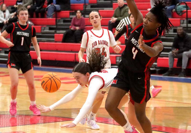 Huntley’s Luca Garlin, bottom, gets tripped up with Mundelein’s Grace Dunigan, right, in varsity girls basketball Komaromy Classic tournament  action on Tuesday, Dec. 30, 2025, at Dundee-Crown High School in Carpentersville.