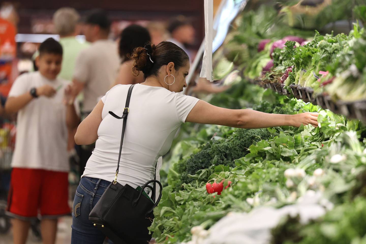Bertha Mungura, of Joliet, picks out some fresh produce at Tony’s Fresh Market grand opening in Joliet. Wednesday, June 28, 2022 in Joliet.