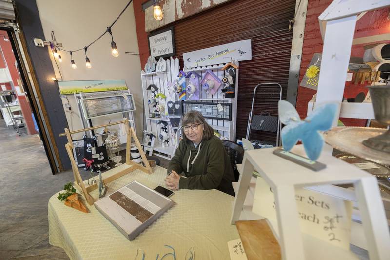 Pam Machan of Farmhouse and Fancy works at her booth at the Twin City Farmers Market Saturday, March 25, 2023. Machan is known for her handmade teapot birdhouses.