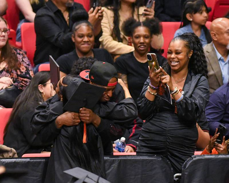 A DeKalb High School graduate gets a hug after receiving  their diploma on Saturday May 23, 2026, during the graduation ceremony held at the Convocation Center in DeKalb.
